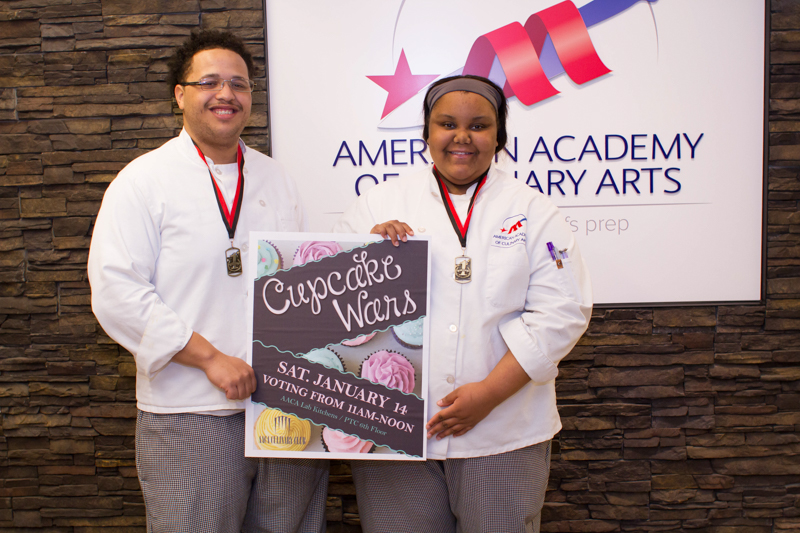 Winners of the Cupcake Wars contest holding a sign