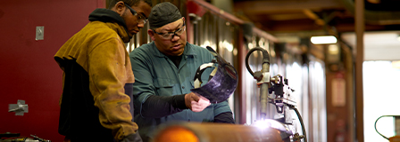 Welder teaching a student how to weld