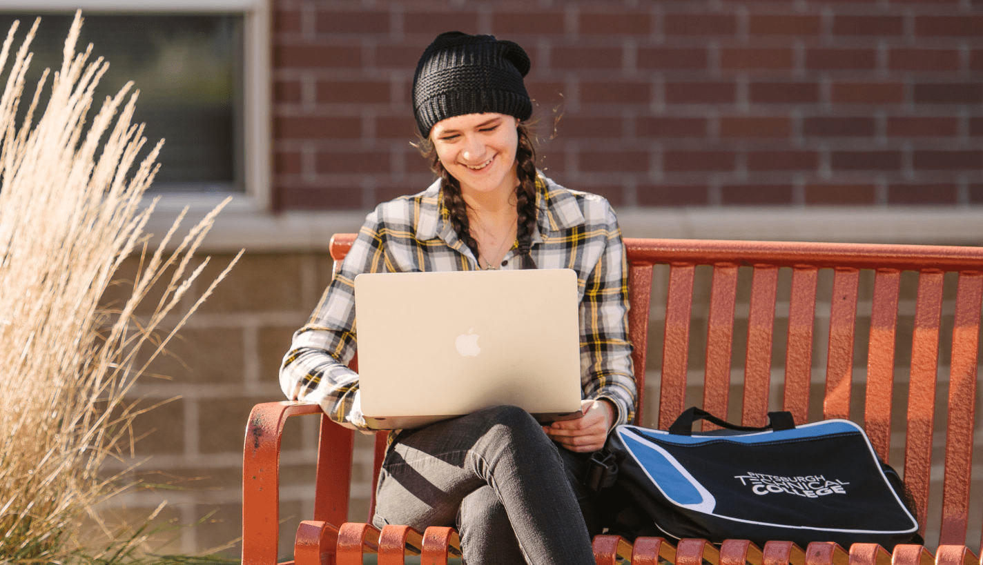 A student sitting outside with her laptop.