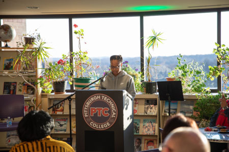Student speaking at a podium in the library