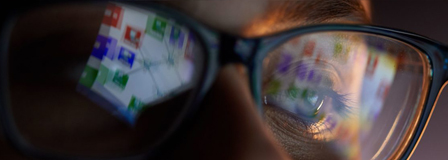 women with computer screen reflecting in her glasses