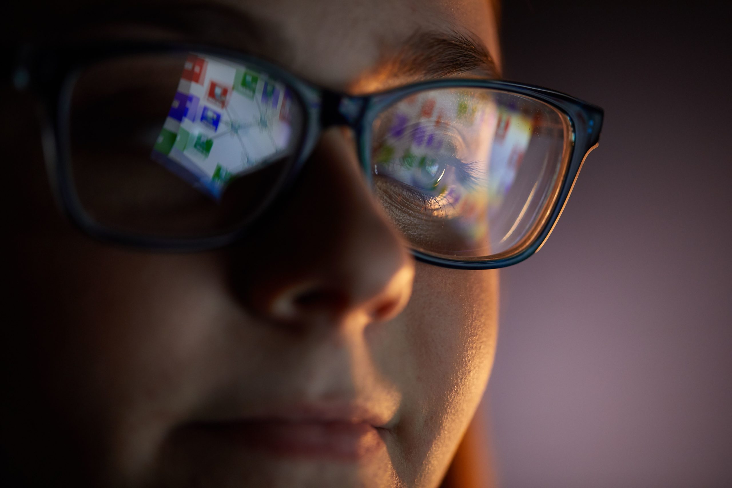 women with computer screen reflecting in her glasses