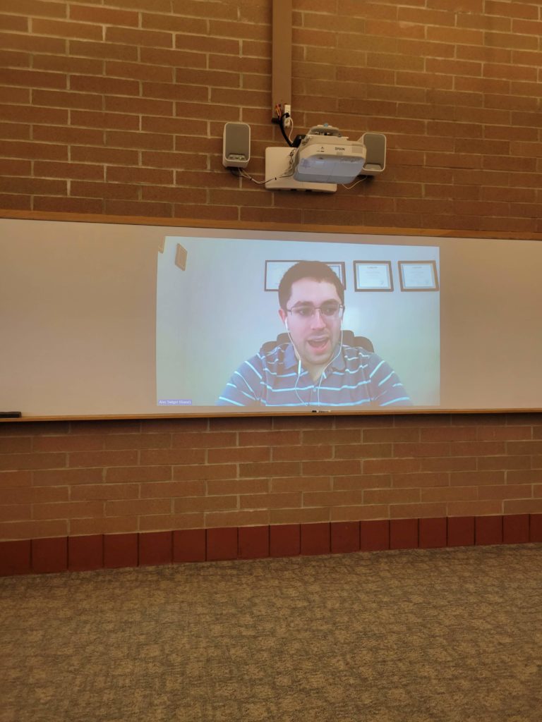 Guest speaker Alec being broadcast into a classroom