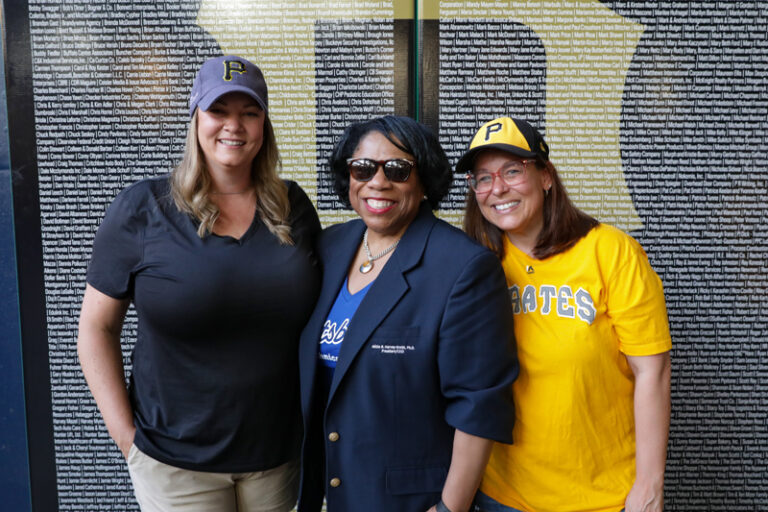 A photo of Dr. Harvey-Smith posing for a group photo at PNC Park Alumni Night event.