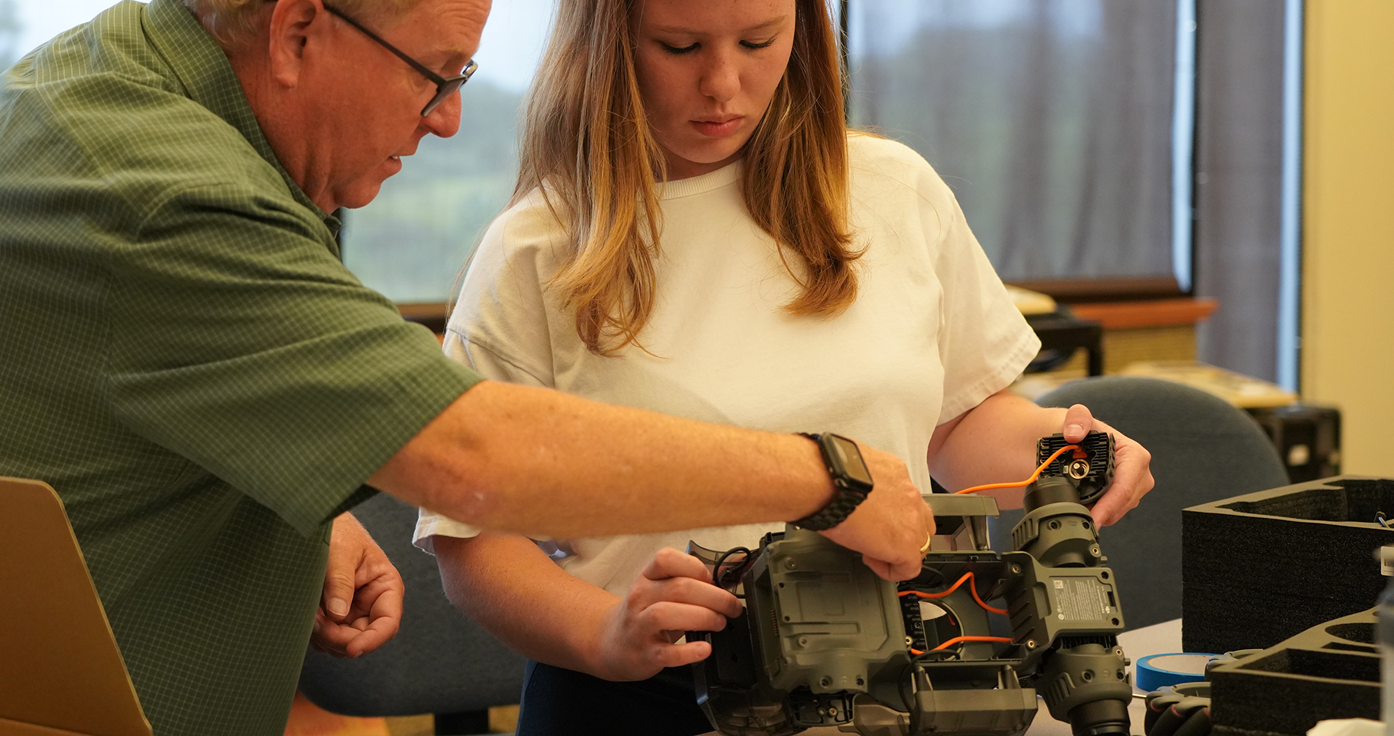 A teacher assisting a student during a Robotics and Autonomous Engineering class.